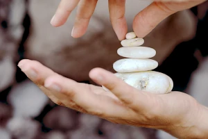 Flache Steine balanciert aufschichten, ein schönes Symbol für ganzheitliche Therapie auf allen Ebenen.